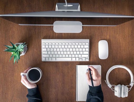 Top view, woman working at the computer, wooden table, office concept, freelancing, remote work.